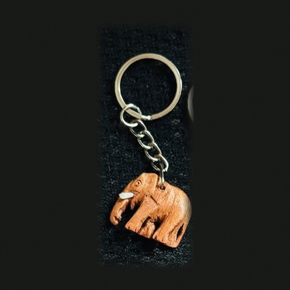 Small carved brown elephant charm keychain with metal ring and chain
