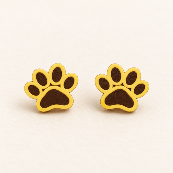 Yellow paw print stud earrings with solid dark brown filled pads, pair on ivory studio background